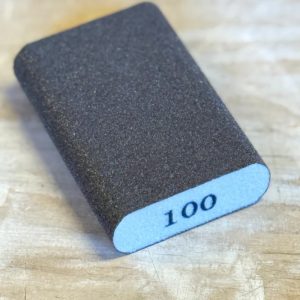 Esponja abrasiva redondeada para madera grano 100 Magic Paint sobre superficie de madera